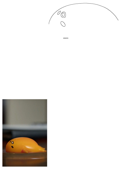 A yellow Gudetama toy, shaped like a lazy egg yolk with simple black facial features, rests casually on a brown table surface.